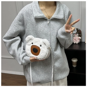 Detail shot of a white plush bear crossbody bag with 3D ears and soft furry texture