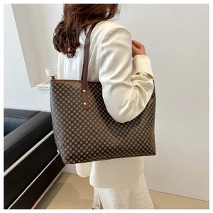 Brown tote bag with geometric print and leather handles shown in a lifestyle setting