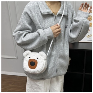 Detailed view of the cute white plush bear crossbody bag worn with a casual gray hoodie