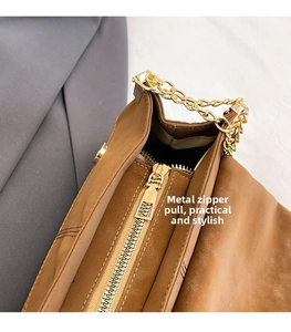 Detail of premium golden metal zipper and stitching on the brown messenger bag