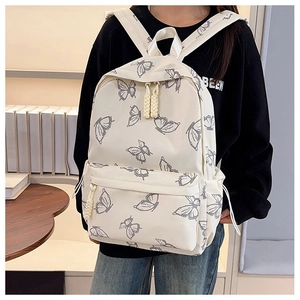 Detail of cream backpack showing grey butterfly prints and woven rope zipper pulls