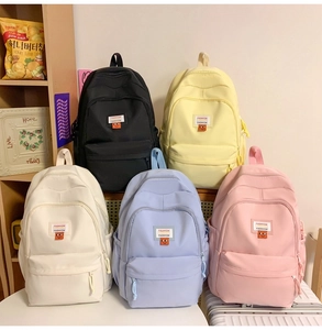 Collection of minimalist canvas backpacks in black, yellow, cream, blue, and pink colors