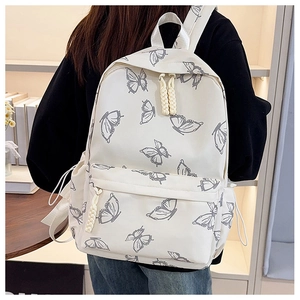 Close-up of white canvas backpack with gray butterfly prints and woven zipper pulls