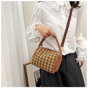 Detail of plaid retro handbag with brown corduroy handles shown on a model