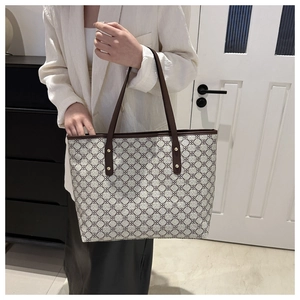 Detail of vintage geometric pattern tote bag with leather handles and gold rivet accents