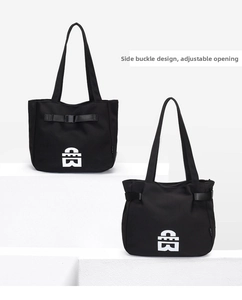 Detail view of large black tote bag with side buckles and white geometric logo for commute