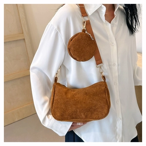 Détail du sac baguette en velours côtelé marron avec large bandoulière et porte-monnaie