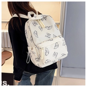 Close-up of white canvas backpack featuring grey butterfly prints and functional side pockets