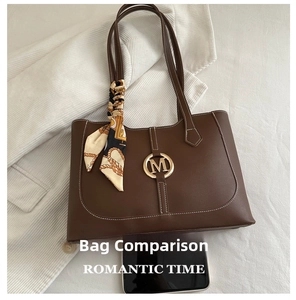 Detail van donkere koffie tote tas met metalen M-logo en elegant zijden sjaal accessoire