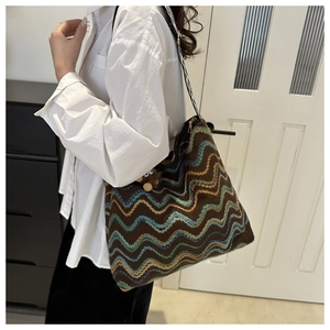 Close-up of retro knit shoulder bag with wave patterns and cute bear charm detail