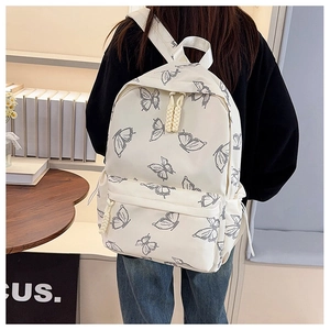 Detail of white butterfly print backpack with rope zipper pulls on durable canvas fabric
