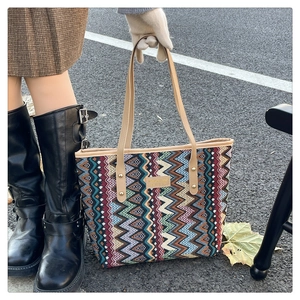 Close-up of vibrant zigzag jacquard tote bag with leather handles and ethnic pattern