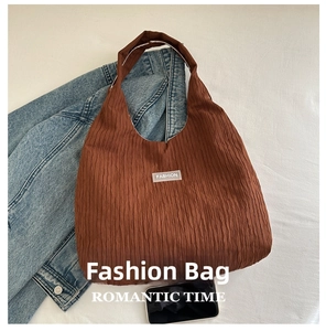 Vue détaillée du sac cabas en velours côtelé marron foncé avec texture et étiquette de mode
