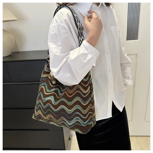 Detail of knitted tote bag with wave pattern and wide geometric jacquard strap