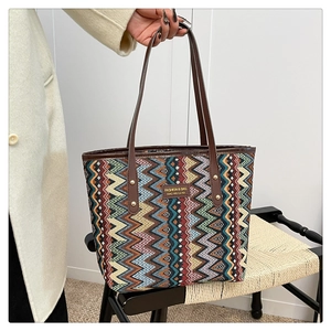 Detail of bohemian tote bag with geometric woven patterns and brown faux leather handles
