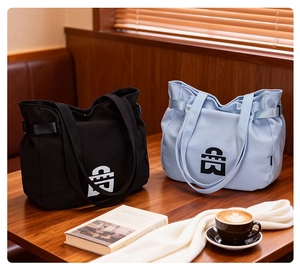 Detail of large canvas tote bags with geometric logo on a wooden cafe table