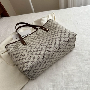 Large vintage tote bag with grey clover pattern and brown leather handles for commuting
