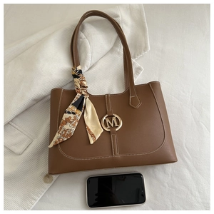 Sac cabas marron avec boucle M dorée, foulard décoratif et smartphone pour comparer la taille