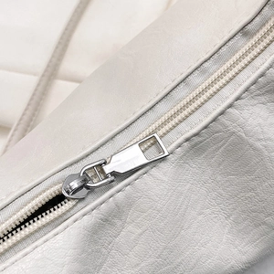 Minimalist beige textured leather tote bag featuring a high-quality metal zipper detail