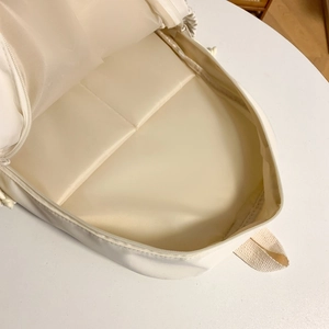 Spacious off-white backpack interior with functional compartments and durable zippers