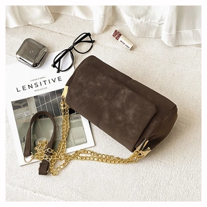 Detail of dark brown cylindrical crossbody bag with vintage quilted suede and gold chain