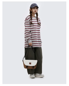 Full body view of a contrast color messenger bag styled with streetwear outfit