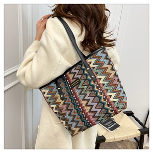 Bohemian zigzag pattern tote bag with leather straps and studs shown on a model
