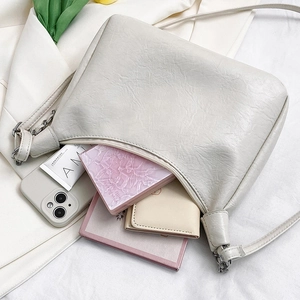 Minimalist beige ruched tote bag with chain detail showing large storage capacity