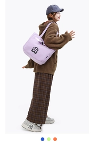 Detail of light purple nylon tote bag with black logo and woven shoulder strap for daily use