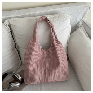 Détail du sac cabas plissé rose avec étiquette Fashion dans un cadre de maison cosy