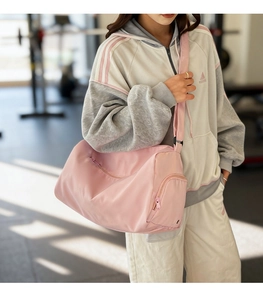 Pink fitness bag detail showing the separate side zippered compartment for shoes or wet items