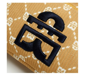Macro d'un tissu en velours côtelé jaune avec monogramme TB brodé bleu et imprimé lettres