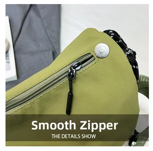 Detail showing smooth metal zipper and engraved silver snap on green ripstop nylon fabric