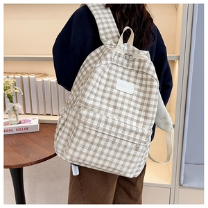 Detail of checkered canvas backpack showing padded shoulder straps and side pocket view