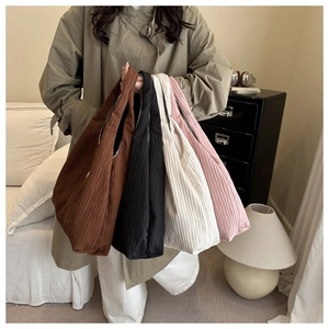 Vue détaillée de la texture plissée des grands sacs fourre-tout en marron, noir et beige