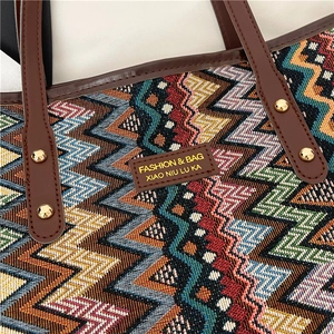 Ethnic style woven tote bag featuring colorful geometric patterns and leather handles