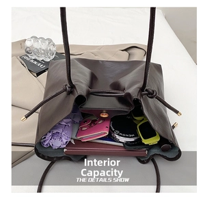 Spacious interior of dark brown tote bag showing capacity for umbrella, sunglasses and book