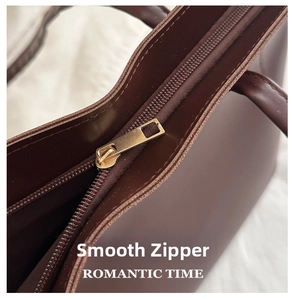 Détail du zip en métal doré lisse sur le sac cabas marron chocolat de haute qualité