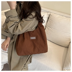 Détail du sac à bandoulière en velours côtelé plissé avec texture marron et étiquette