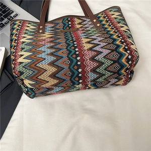 Ethnic style tote bag with colorful geometric patterns and brown leather handles