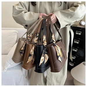 Detail van retro tote bags in beige, bruin en zwart met decoratieve zijden sjaals