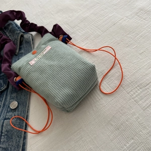 Mint green corduroy crossbody mini bag with purple pleated strap and orange drawstring