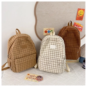 Detailed shot of vintage corduroy plaid backpacks in beige, camel, and coffee colors