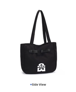 Side view of black canvas tote bag showing reinforced handles and ribbon detail