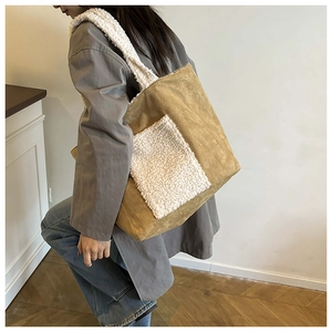 Detail view of khaki corduroy tote bag with white faux shearling trim worn by a model