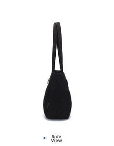 Side view of black canvas tote bag showing metal zipper detail and sturdy shoulder strap