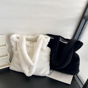Detail of plush faux fur tote bags in black and white with soft texture and metal clasp