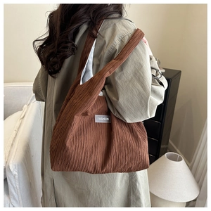 Détail du grand sac cabas marron foncé avec texture plissée et étiquette de mode