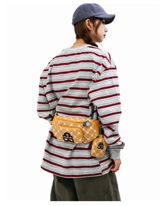 Détail d'un sac bandoulière jaune gingembre avec petite pochette amovible et logo streetwear