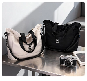 Borse tote in nylon bicolore nero e crema con tracolle regolabili e tasche laterali pratiche